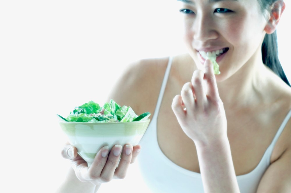 Young woman eating salad